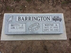 Granite double headstone with carved symbols