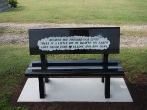 Black memorial bench with engraved dedication