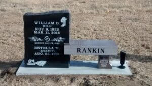 Black headstone and stone memorial bench