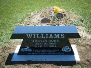 Black granite gravestone with flowers
