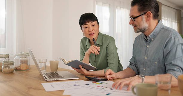 Two people reviewing financial charts at table