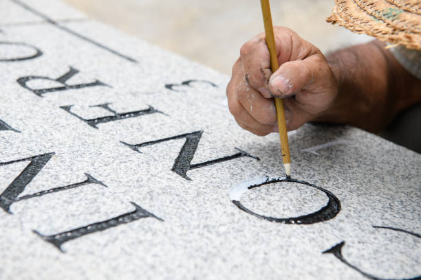 Hand painting carved stone letters with brush